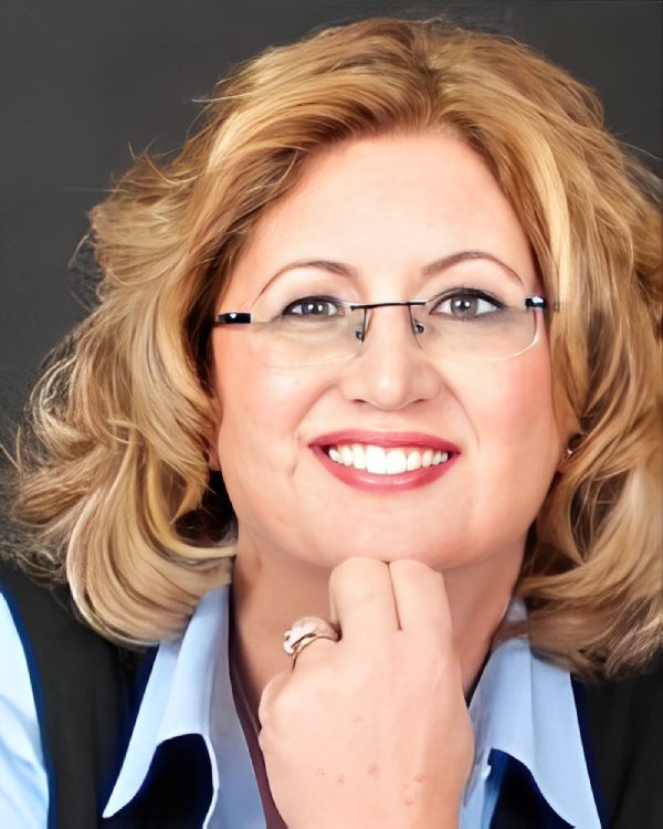 Smiling person with glasses and blonde hair.