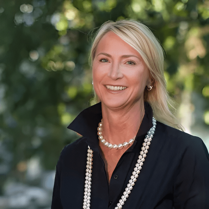 Smiling woman outdoors with blurred background.