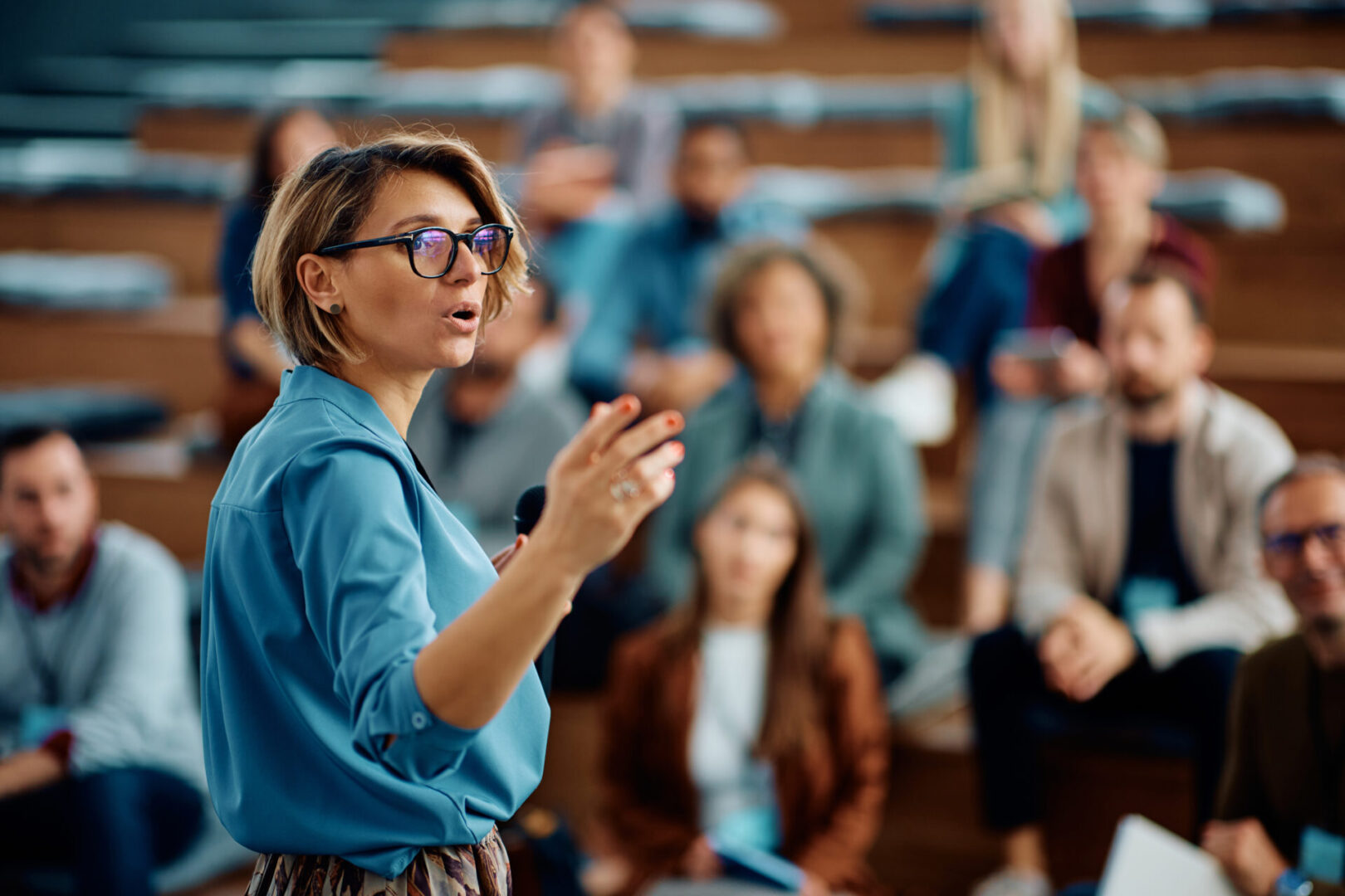 Speaker addressing audience in a lecture hall.