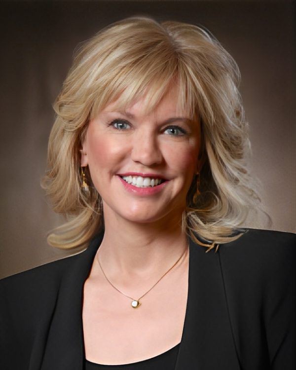 Smiling woman with blonde hair and blazer.