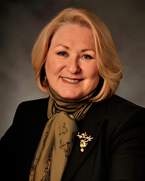 Smiling woman with blonde hair and scarf.