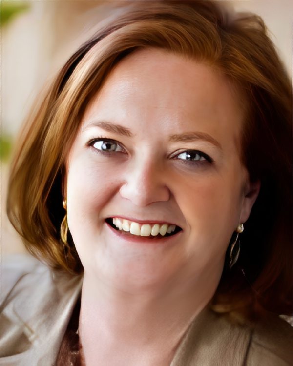Smiling woman with short, auburn hair.